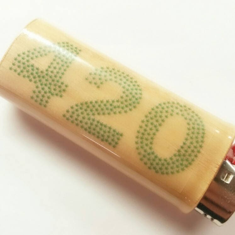 Close-up of a 420 Pot Leaf lighter case with green text on a white background