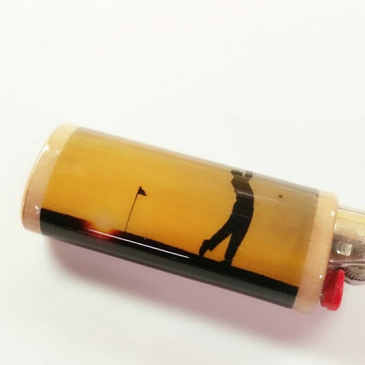Cylindrical object with a golf-themed design on a white background