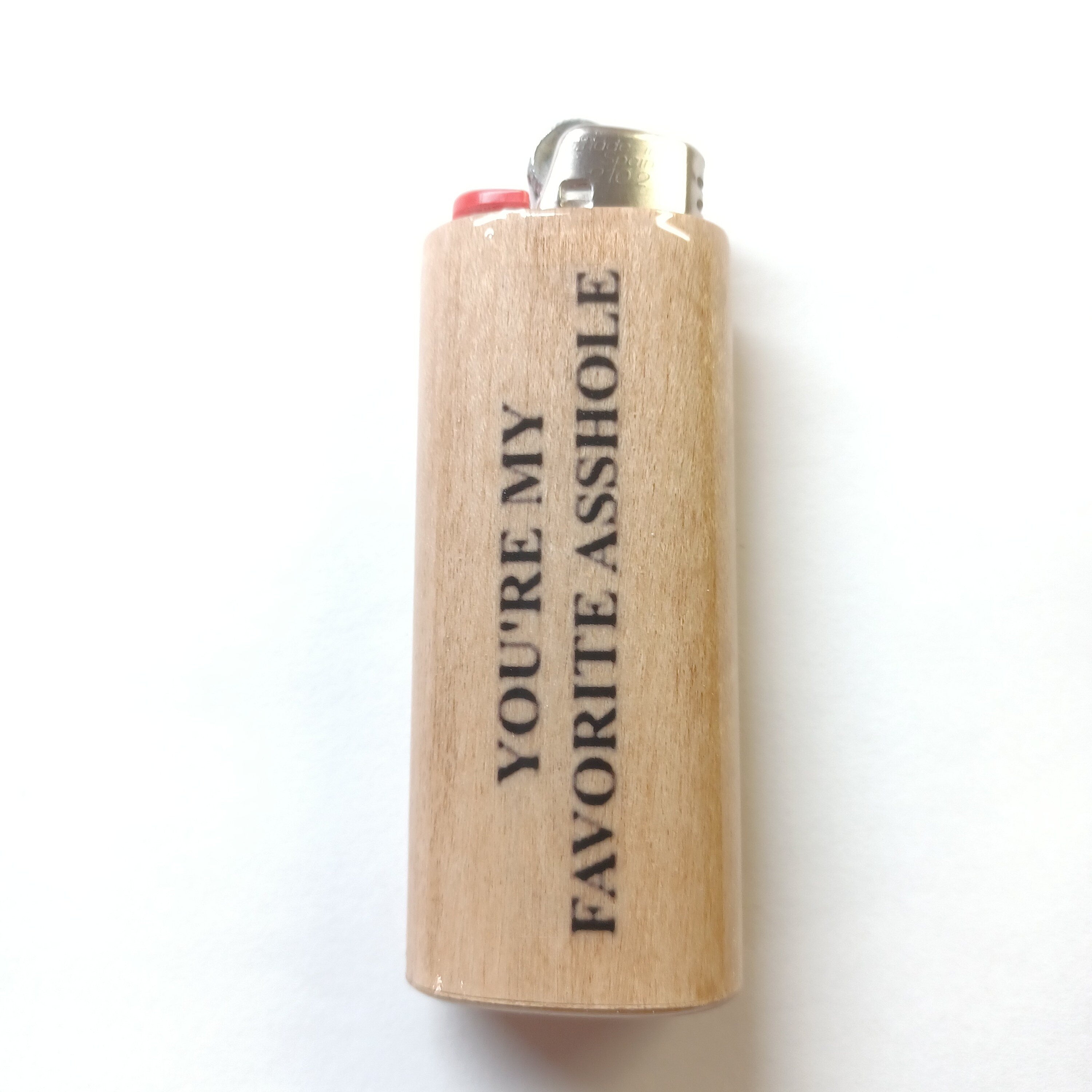 Lighter with text 'YOU'RE MY FAVORITE ASSHOLE' on a white background