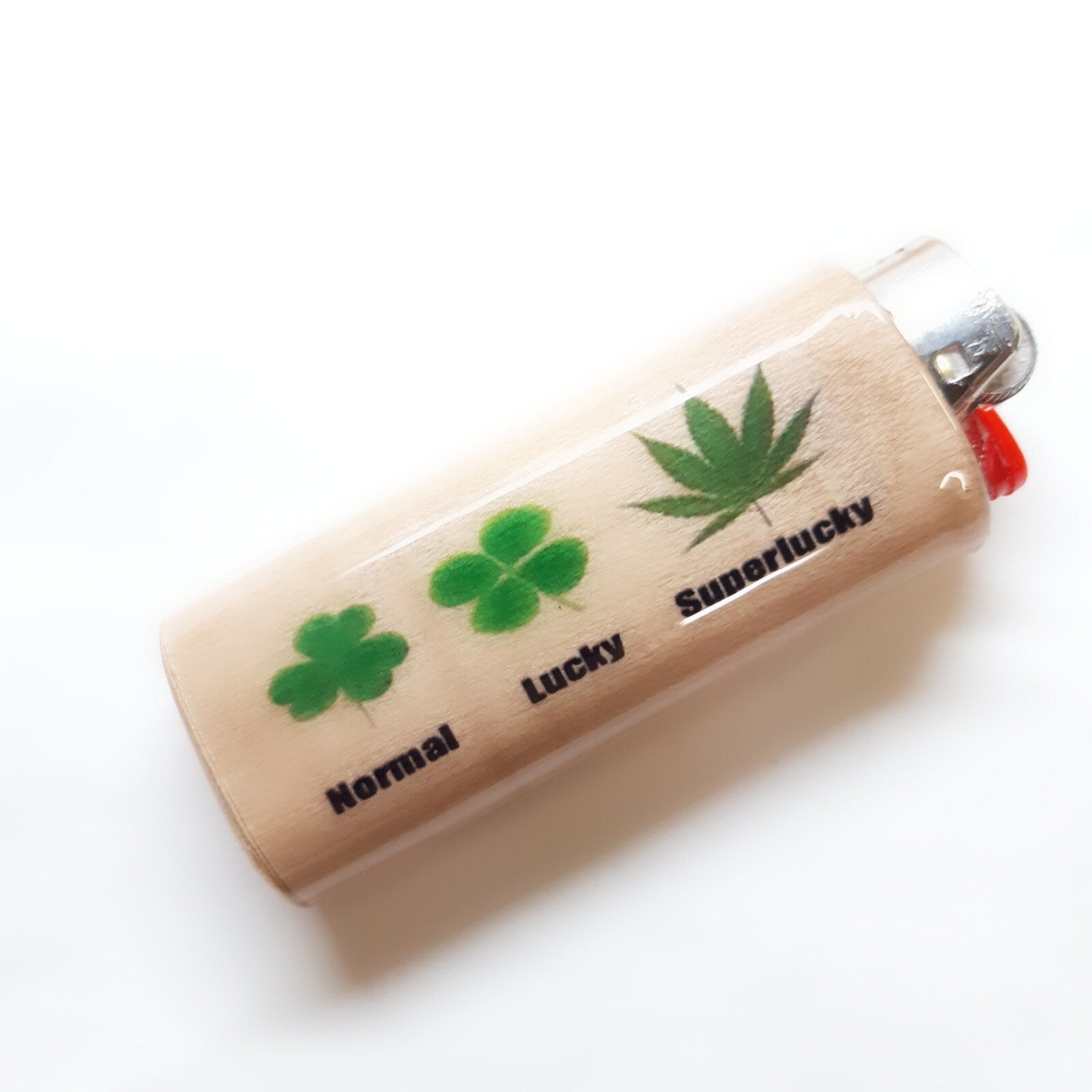 Lighter with four-leaf clover and marijuana leaf designs on a white background