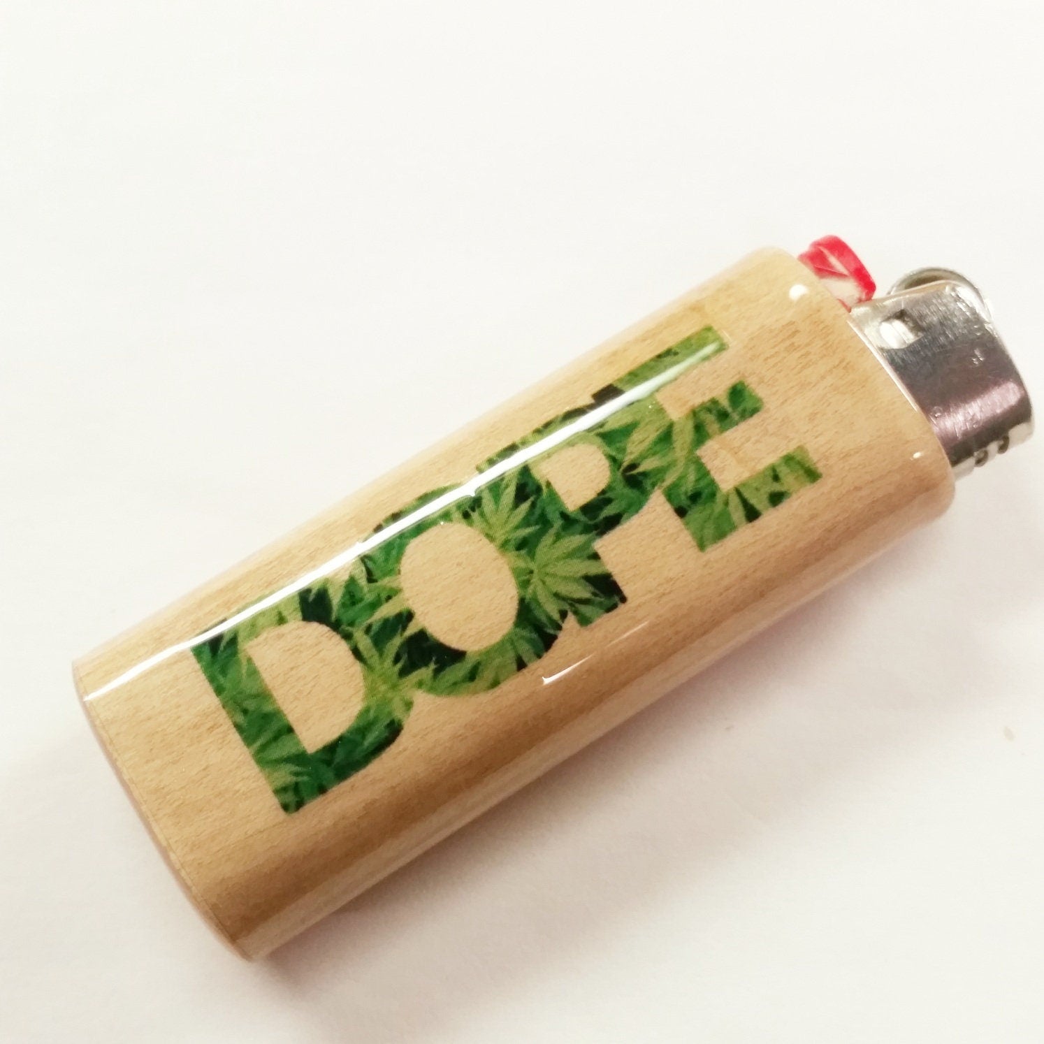 Lighter with 'Dope' text made of marijuana leaves on a white background