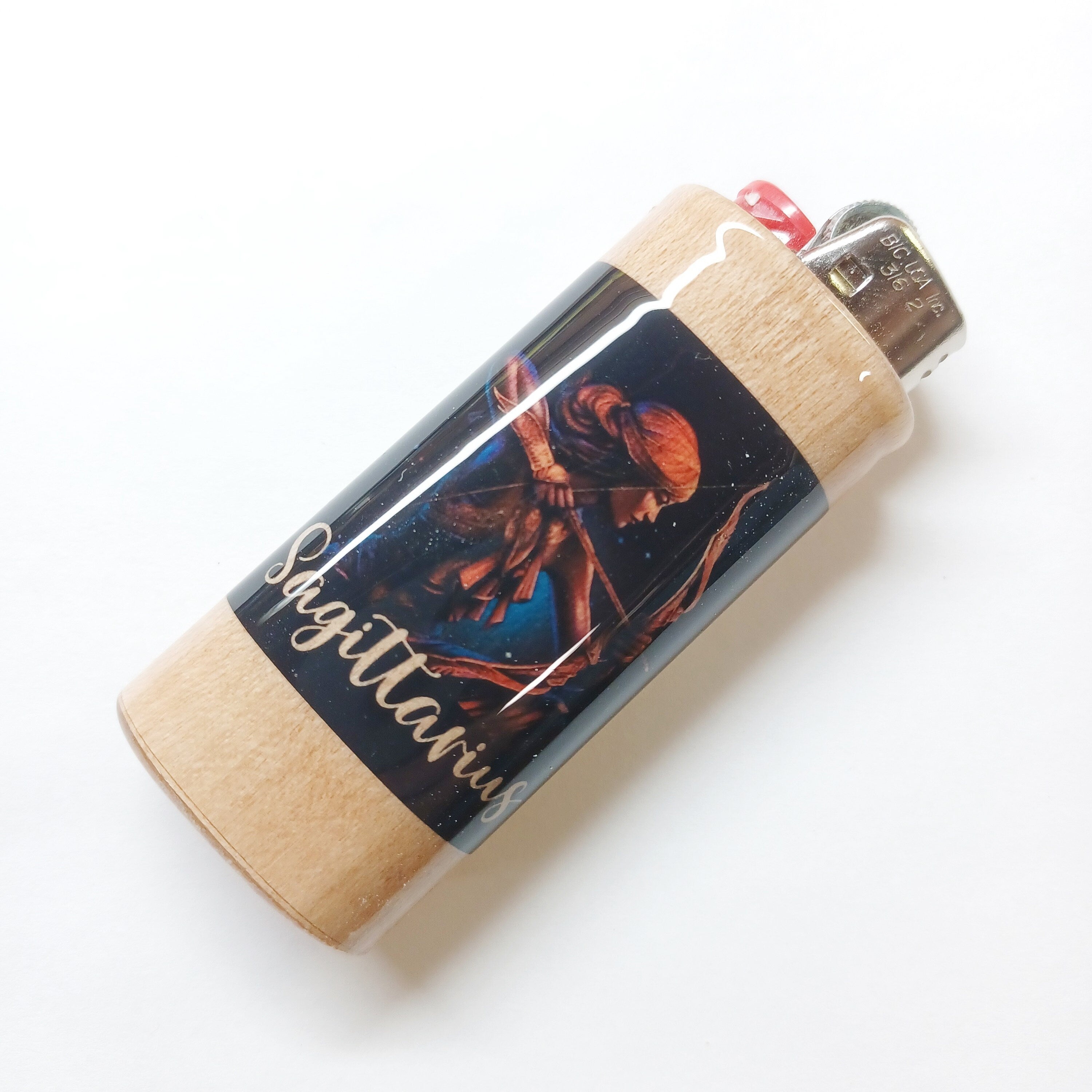 Lighter with a decorative cover featuring an astrological design on a white background