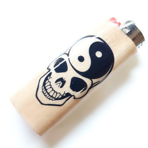 Lighter with skull and yin yang design on a white background