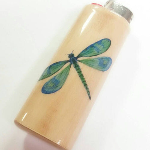 Lighter with a green dragonfly design on a beige background