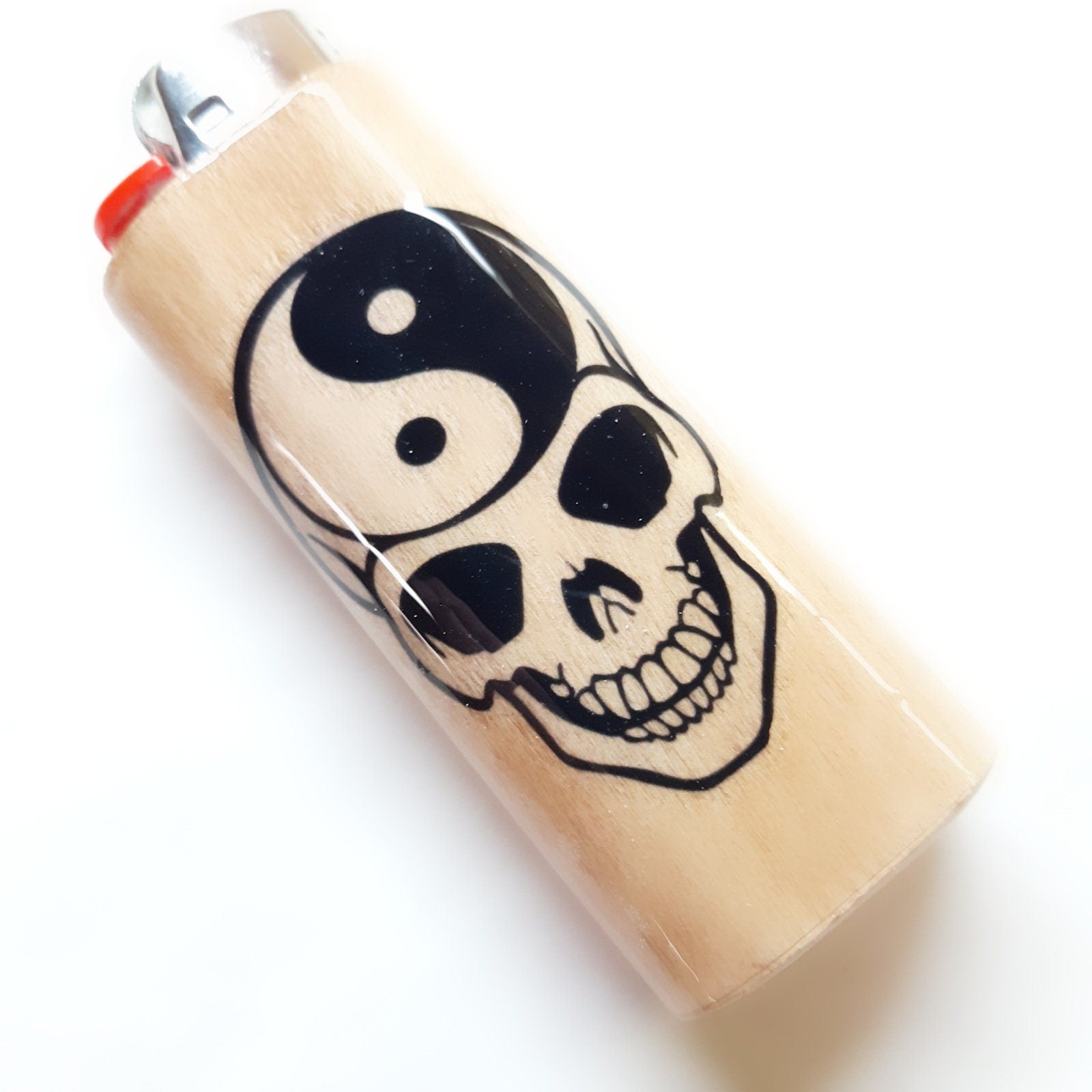 Lighter with skull and yin yang design on a white background