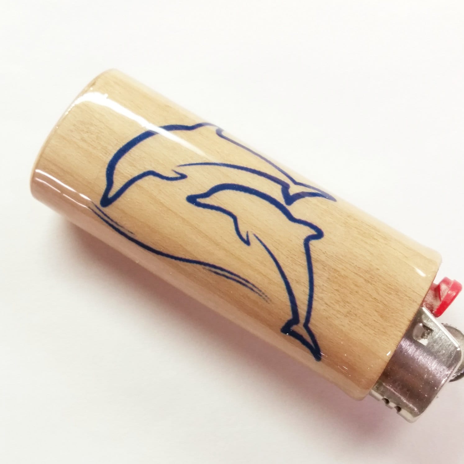 Wooden lighter with a dolphin design on a white background