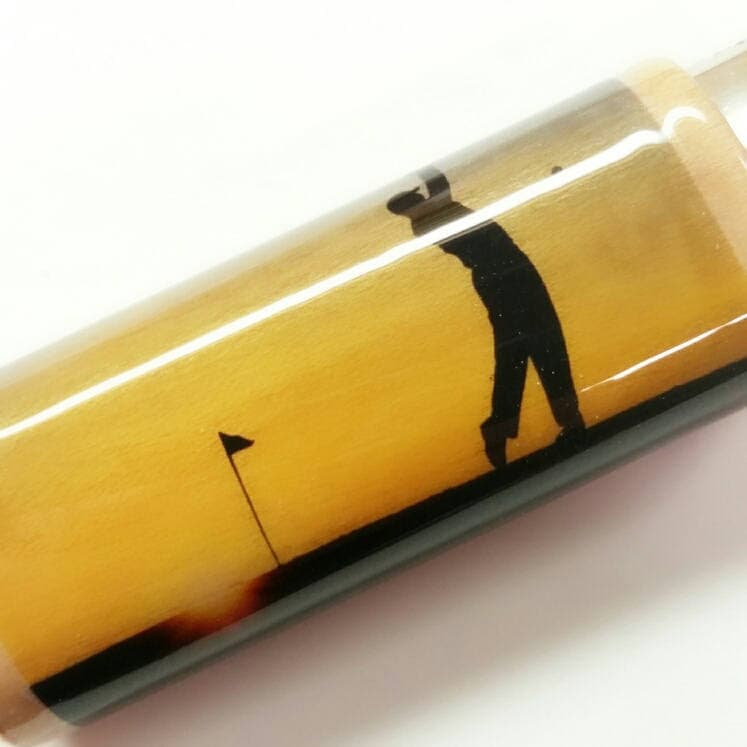 Golf-themed pen with a silhouette of a golfer and flag on a yellow background