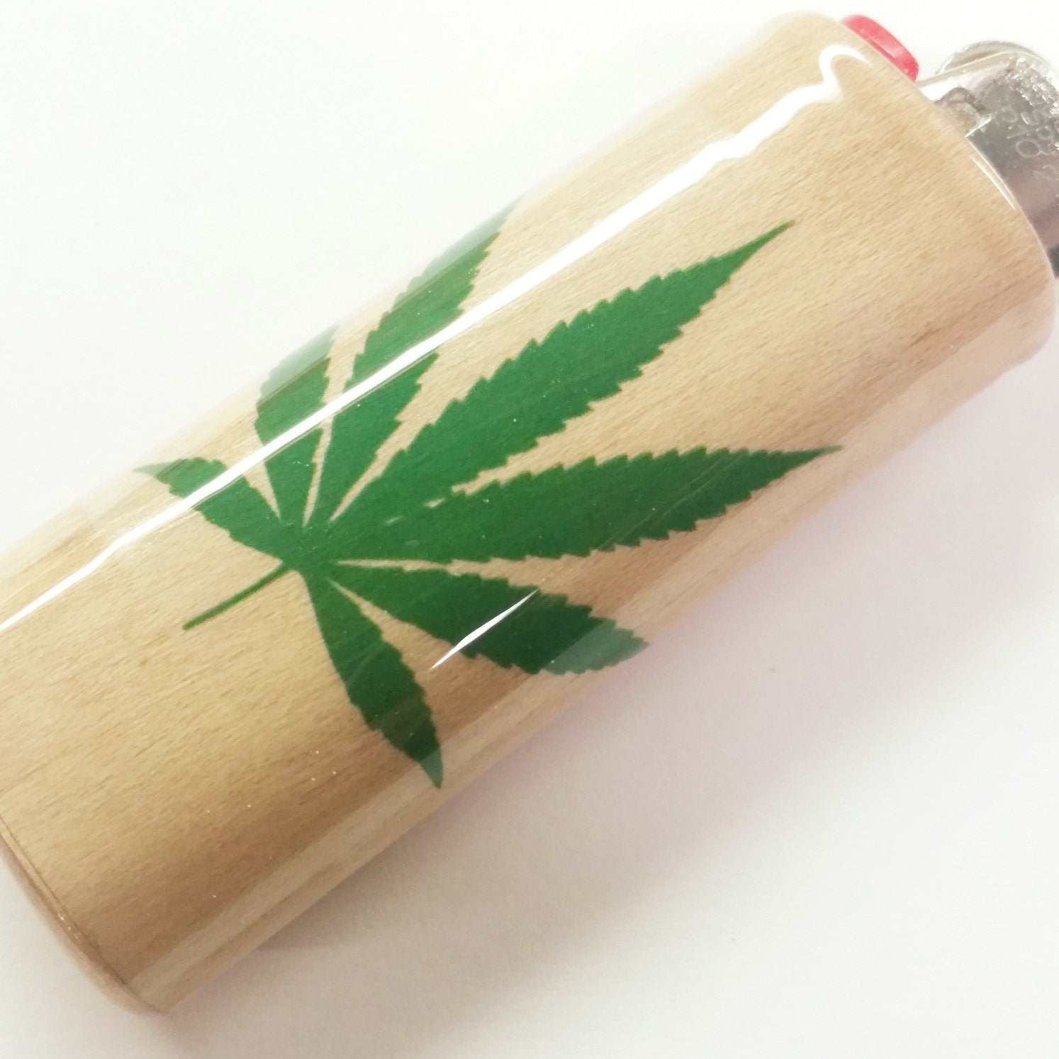 Lighter with a green cannabis leaf design on a white background