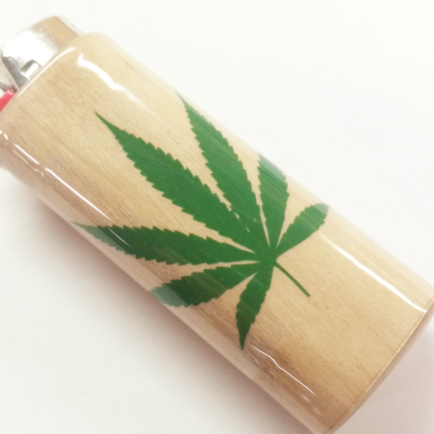Lighter with a green cannabis leaf design on a white background