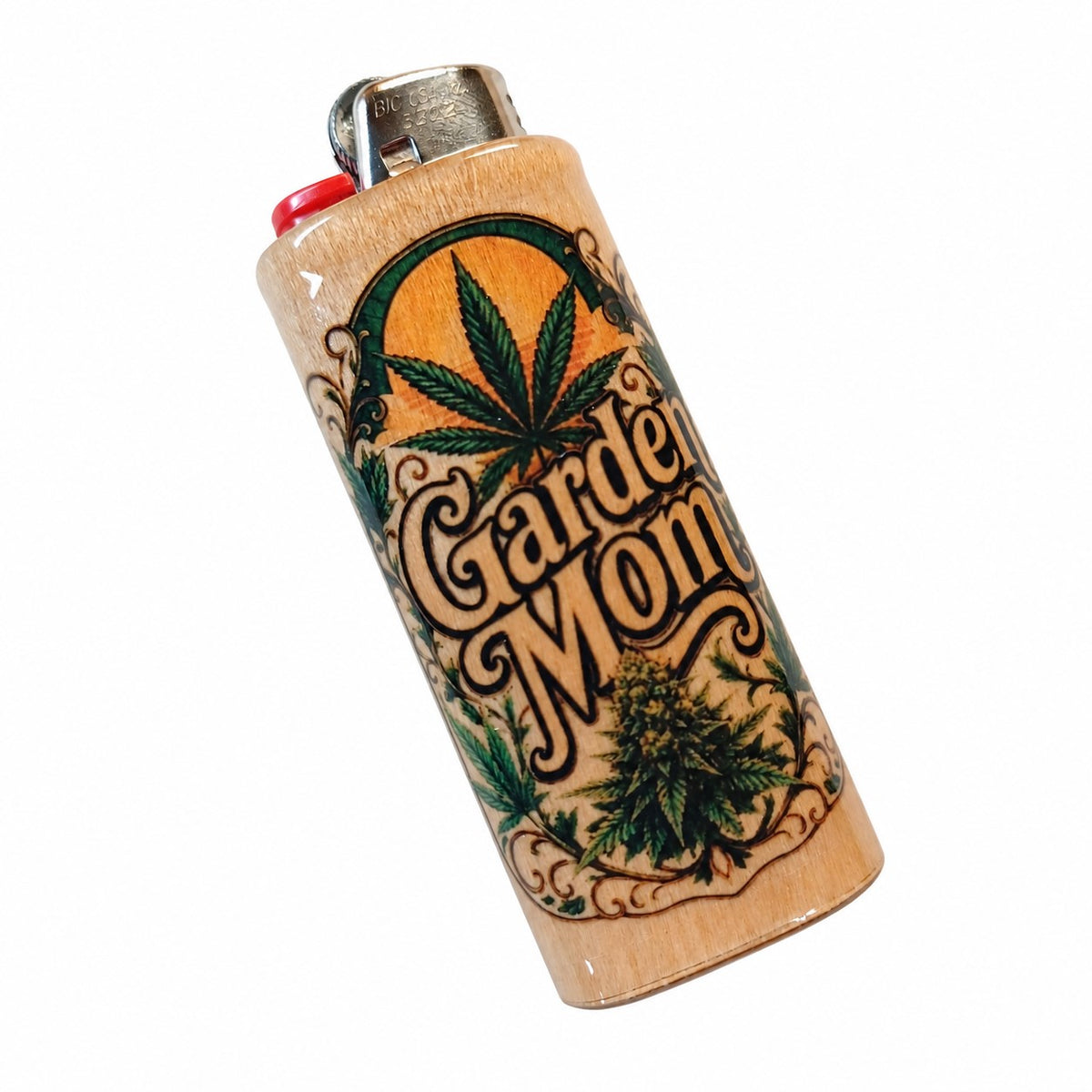 A novelty lighter with a light wood grain body featuring a hand-painted design of cannabis leaves, a bud, and the words 'Garden Mom' in stylized lettering. It has a silver metal top and a red ignition button, shown on a plain white background.