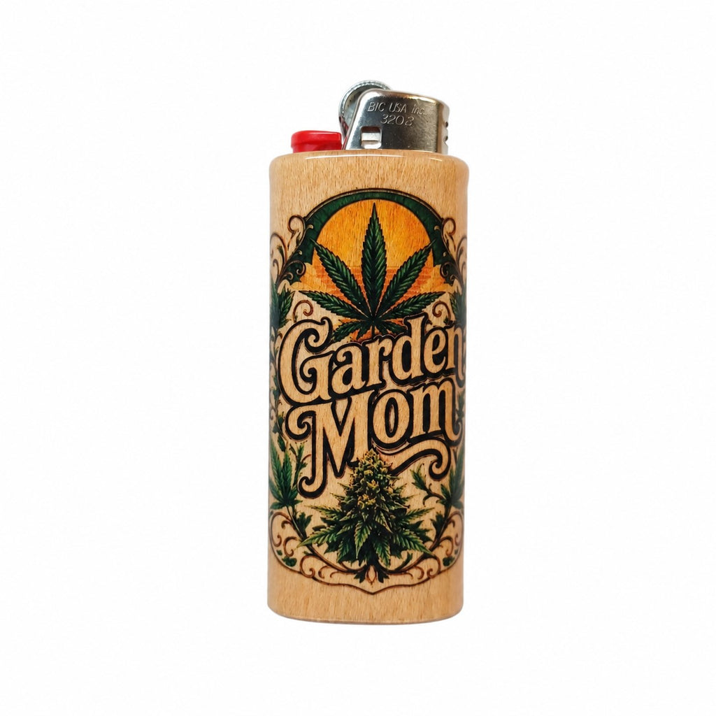 A wooden lighter with a natural wood grain finish, featuring a printed graphic of a cannabis leaf, a bud, and the words 'Garden Mom' in a decorative font. The lighter has a red plastic top and a silver metal ignition button.
